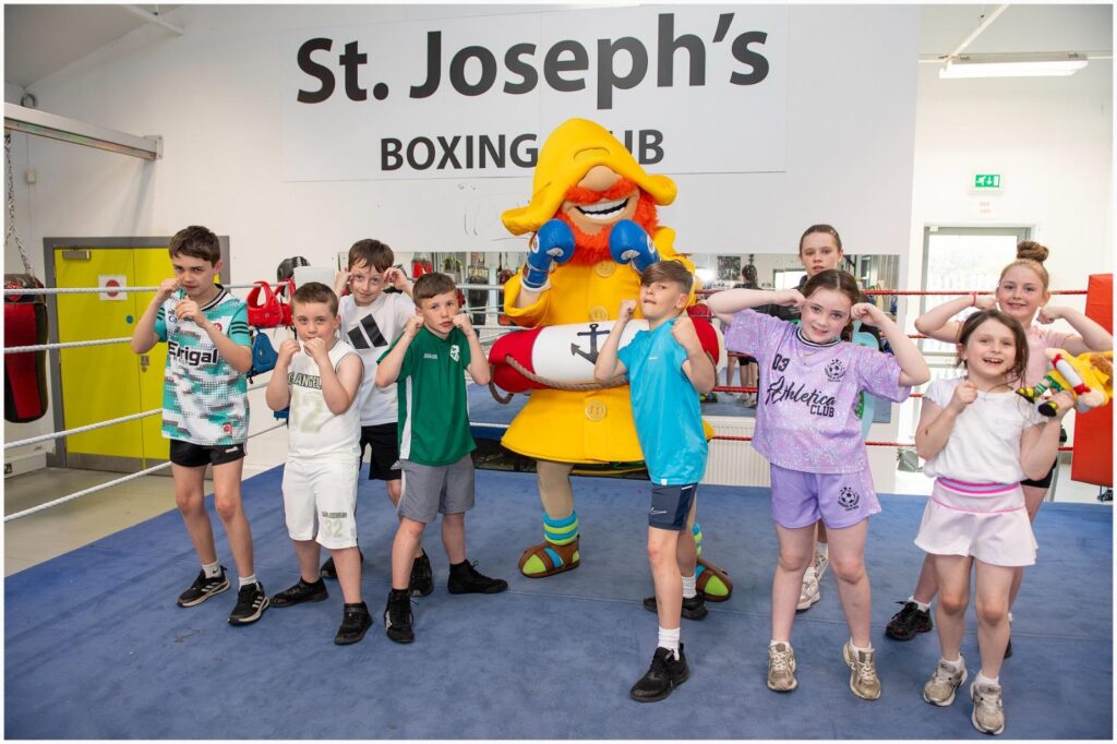 CompareNI mascot Fisherman Rod pictured with a local boxing club, awarded the Fish4Funds charity donation.